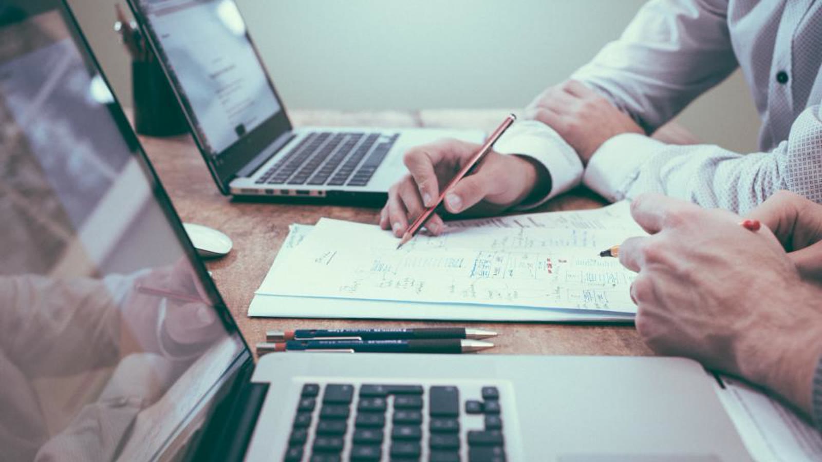 People writing on paperwork at a desk